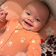 Lakelee is registered to the contest to win money with this photo: baby, blanket, child, comfort, cozy, cute, face, flower_pattern, hand, happy, indoors, infant, lying_down, nursery, orange_onesie, pacifier, smiling, soft_toys, star_wallpaper, strawberry_pattern