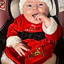 baby, infant, christmas_outfit, santa_hat, red_clothing, white_fur_trim, car_seat, happy, smiling, cute, holiday, festive, child, portrait, indoors, clothing, seatbelt, white_tights, reindeer_embroidery, black_bow