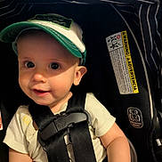 Reese joined the competition — help win amazing prizes! baby, cap, car_seat, child, smile, straps, clothing, infant, seatbelt, warning_label, striped_fabric, cute, safety, young_child, portrait, indoor, headwear, black_straps, happy, closeup