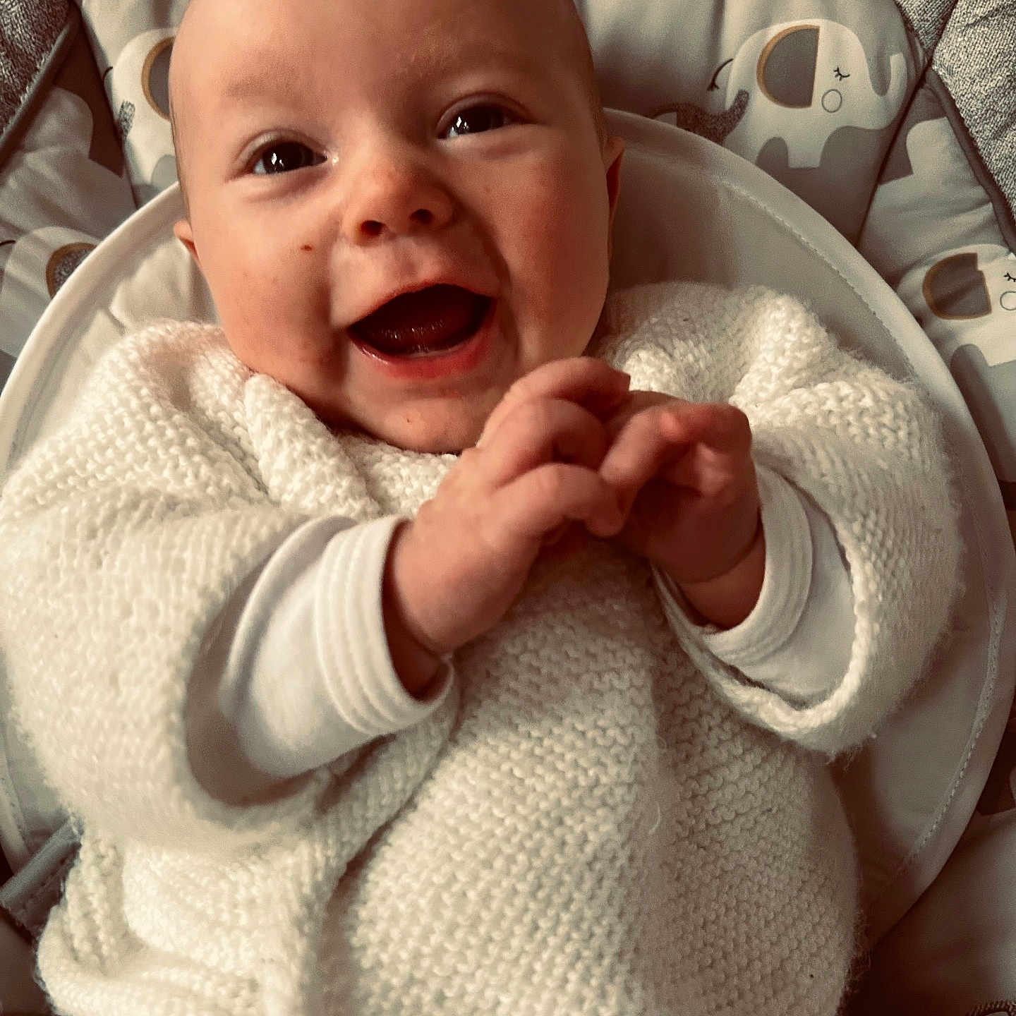 Charli participe au concours pour gagner de l'argent avec cette photo : baby, smiling, happy, clapping_hands, white_sweater, knitted, infant, cute, face, eyes, human, child, seat, cushion, elephant_pattern, indoor, portrait, joyful, closeup, cozy