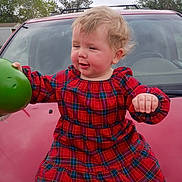 Elizabeth joined the competition — help win amazing prizes! blond_hair, car, casual, child, cloudy_sky, cute, daytime, expression, face, green_object, hood, motion, outdoor, person, plaid, red_dress, suburban, toddler, trees, young