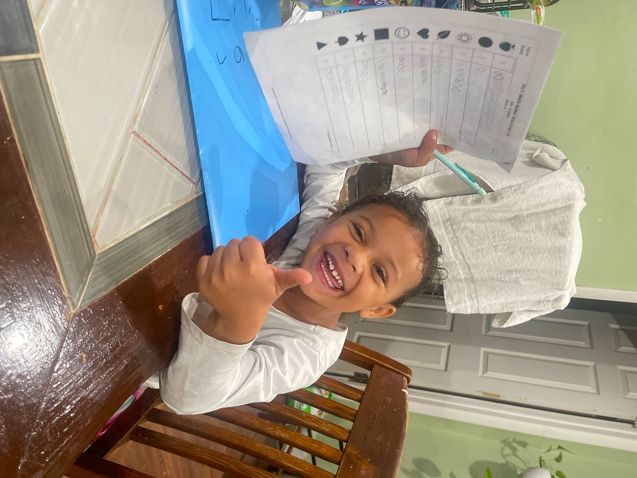 Laila is registered to the contest to win money with this photo: cabinetry, chest_of_drawers, child, cupboard, drawer, fun, happy, joy, laugh, leisure, newspaper, paper, paper_product, person, publication, reading, room, sitting, smile, t_shirt