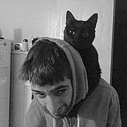 Thomas joined the competition — help win amazing prizes! animal, black_and_white, black_cat, candid, casual, companion, cozy, domestic, feline, hoodie, household, human, indoor, looking_away, man, pet, portrait, refrigerator, shoulder, young_man