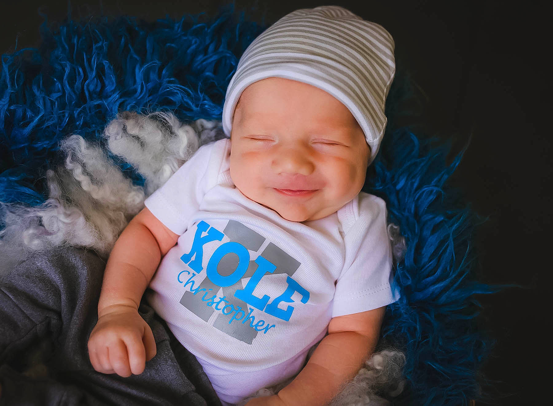 Kole is registered to the contest to win money with this photo: baby, beanie, blue, bonnet, cap, child, headgear, headwear, knit_cap, person, smile, toddler