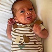 Elyam participe au concours pour gagner de l'argent avec cette photo : baby, newborn, infant, striped_clothing, dog_embroidery, white_blanket, cute, smiling, hand, face, portrait, lying_down, soft_light, indoors, child, young, person, sleepwear, happy, closeup