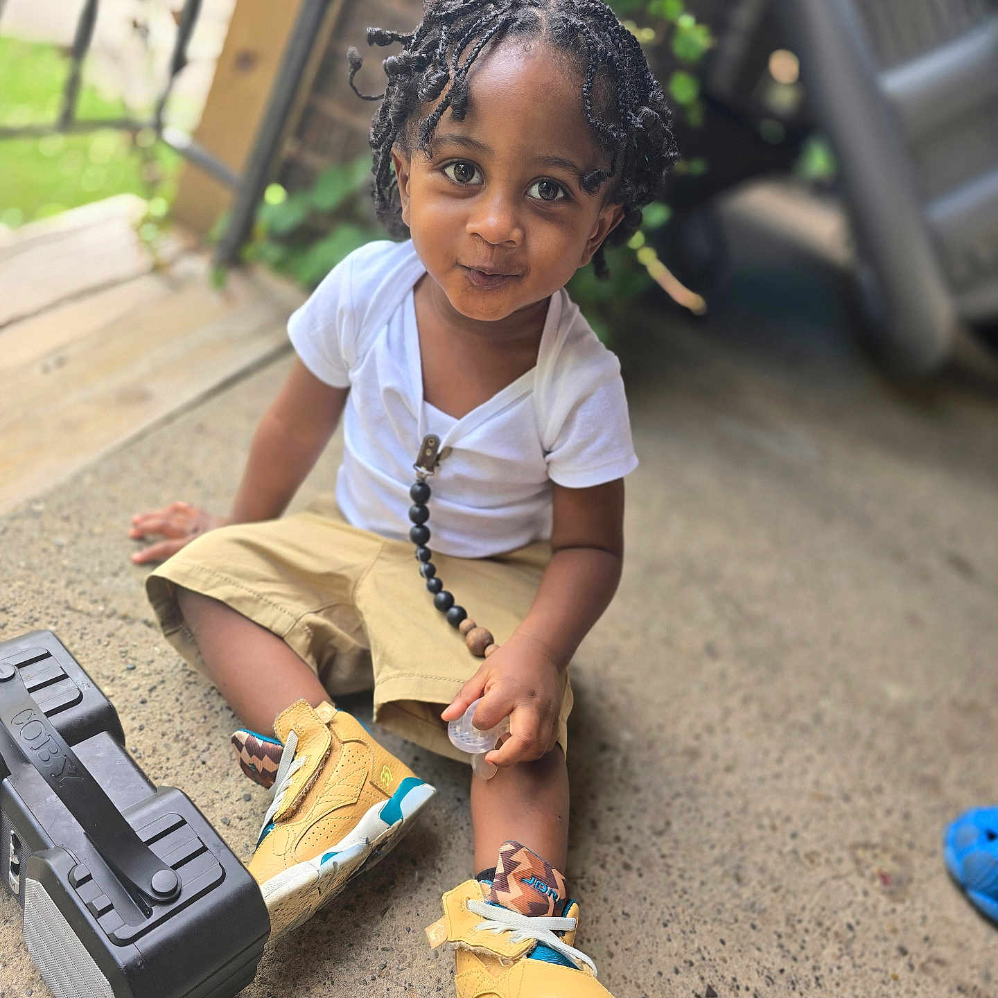 Joaquin is registered to the contest to win money with this photo: accessories, blackhair, child, clothing, face, female, footwear, girl, gun, hair, head, jewelry, necklace, person, photography, portrait, shoe, sitting, sleeve, weapon