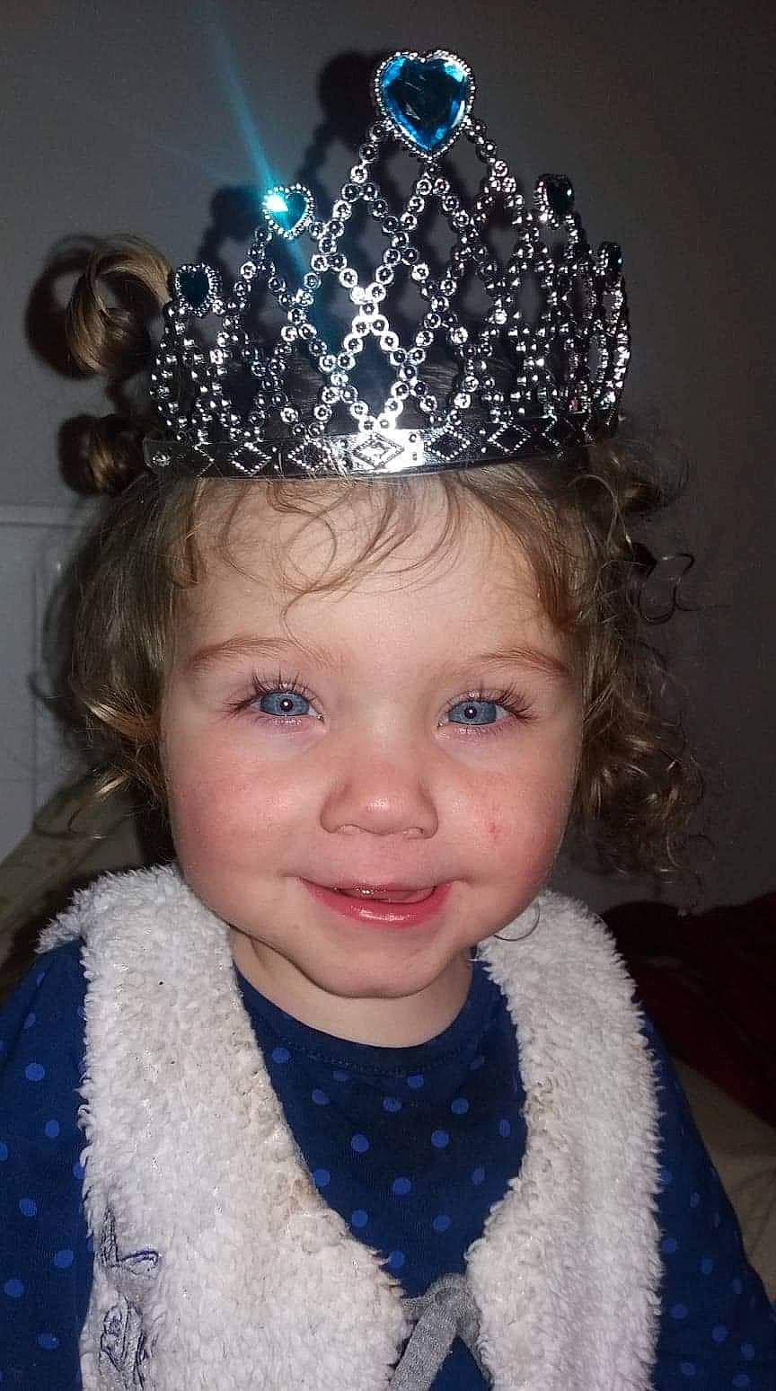 Aisa participe au concours pour gagner de l'argent avec cette photo : child, clothing, costume_accessory, costume_hat, crown, fashion_accessory, forehead, hair, hair_accessory, hat, head, headband, headgear, headpiece, jewellery, joy, person, tiara, toddler