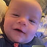 Weston is registered to the contest to win money with this photo: baby, smiling, face, pajamas, indoor, couch, blanket, video_call, infant, child, portrait, cozy, person, head, expression, home, furniture, technology, cute, closeup
