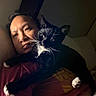 Gojo joined the competition — help win amazing prizes! person, cat, indoor, black_cat, white_paws, tuxedo_cat, whiskers, face, portrait, bedroom, pillow, soft_lighting, closeup, relaxing, companionship, pet, animal, cuddling, resting, nighttime
