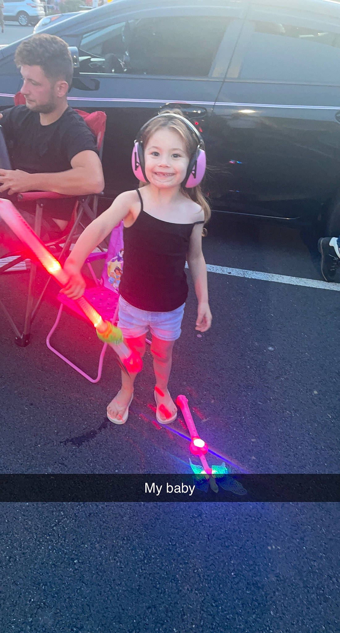Khloe is registered to the contest to win money with this photo: automotive_exterior, automotive_lighting, bumper, electric_blue, entertainment, event, fun, happy, joy, leisure, luxury_vehicle, magenta, neon, person, pink, recreation, sandal, shorts, smile, t_shirt