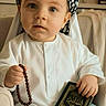 Ibrahim a rejoint le concours — aidez-le/la à gagner de superbes lots ! book, calm, chair, child, cultural, curious, cute, expression, headwear, indoors, innocent, person, portrait, prayer_beads, religion, seated, toddler, traditional_clothing, young