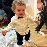 Ibrahim participe au concours pour gagner de l'argent avec cette photo : adult, bow_tie, carpet, casual_clothing, celebration, child, curly_hair, family, floor, happy, home, indoor, party_balloon, person, rug, smile, socks, toddler, walking, white_shirt