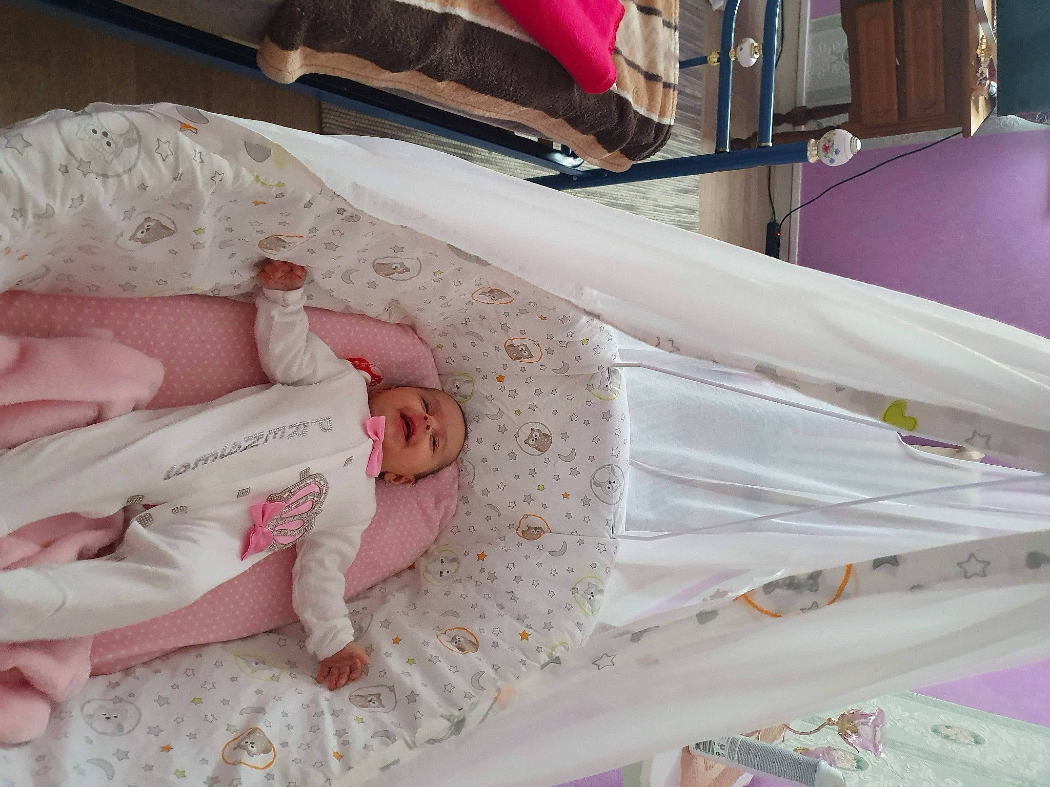 Amina participe au concours pour gagner de l'argent avec cette photo : baby, baby_products, bed, bed_sheet, bedding, birth, child, cradle, furniture, infant_bed, linens, person, pink, product, room, textile