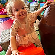 Connie joined the competition — help win amazing prizes! toddler, child, curly_hair, indoor_playground, colorful, soft_play_equipment, orange_cushion, brown_padded_shape, play_mats, happy, smiling, casual_clothing, pink_outfit, legs, hands, play_area, other_children, background, fun, active