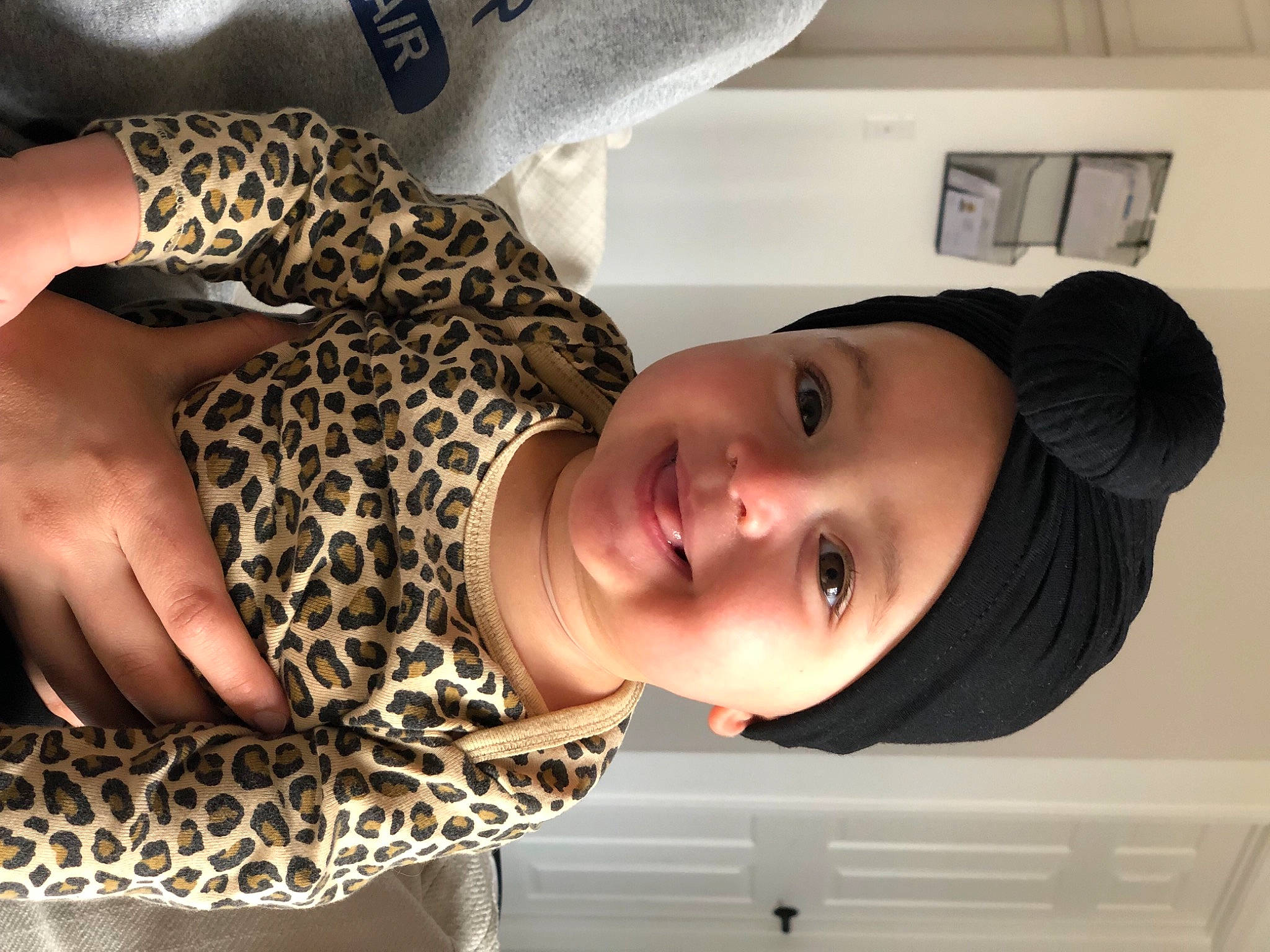 Rainey is registered to the contest to win money with this photo: baby_toddler_clothing, cheek, elbow, eyelash, facial_expression, gesture, happy, hat, headwear, human_leg, joy, lip, mouth, neck, nose, person, shoulder, skin, smile, thigh