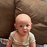 Messiah is registered to the contest to win money with this photo: baby, child, infant, sitting, portrait, face, wide_eyed, curious, indoors, couch, cushion, stuffed_animals, plush_toys, blanket, onesie, toy, home, living_room, vertical_photo, baby_portrait