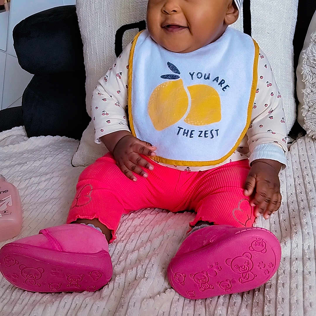 Namra-Nour a rejoint le concours — aidez-le/la à gagner de superbes lots ! baby, bib, blanket, child, clothing, cushion, decor, footwear, happy, headband, indoor, infant, person, pink_pants, pink_shoes, plant, portrait, smiling, sofa, teddy_bear_pattern