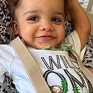 Rustyn is registered to the contest to win money with this photo: toddler, child, smiling, curly_hair, shirt, suspenders, green_pants, animal_print, lion, rhinoceros, cute, happy, portrait, indoor, person, clothing, fabric, pattern, resting, closeup