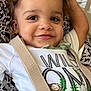 toddler, child, smiling, curly_hair, shirt, suspenders, green_pants, animal_print, lion, rhinoceros, cute, happy, portrait, indoor, person, clothing, fabric, pattern, resting, closeup