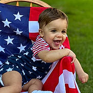Rustyn joined the competition — help win amazing prizes! american_flag, baby, celebration, chair, child, clothing, cute, grass, happy, lawn, outdoor, person, playful, portrait, smiling, sock, stars, stripes, summer, toddler