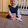 baby, child, toddler, carpet, dress, white_tights, crib, room, floor, furniture, card, person, hair_tie, indoor, cute, smiling, sitting, toy, wooden_floor, soft_lighting