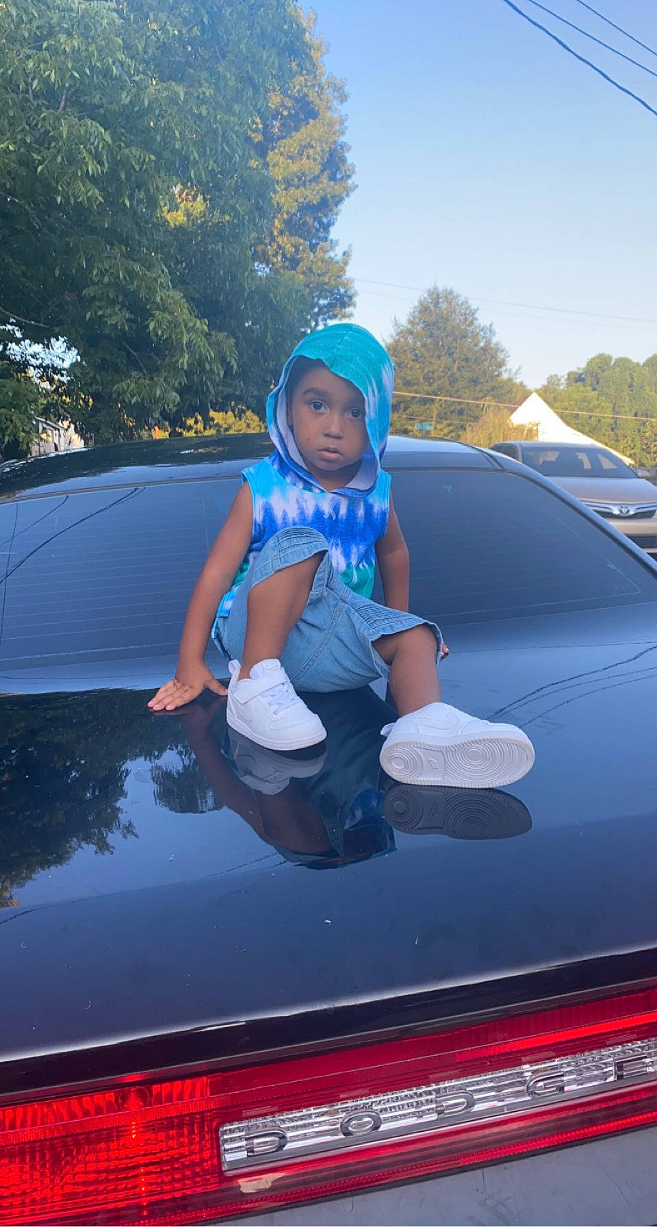 Derrick is registered to the contest to win money with this photo: automotive_design, automotive_exterior, automotive_lighting, automotive_tire, bumper, car, fender, grille, headlamp, headwear, hood, motor_vehicle, person, personal_luxury_car, sky, tints_and_shades, tree, trunk, vehicle, vehicle_door