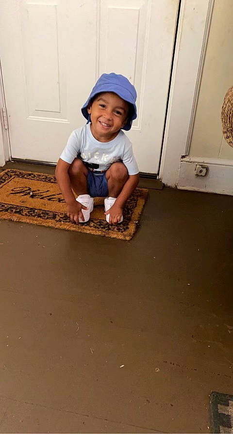 Derrick joined the competition — help win amazing prizes! baby, baby_toddler_clothing, baseball_cap, cap, child, concrete, door, flooring, foot, fun, hardwood, hat, headwear, human_leg, joy, person, sitting, sleeve, smile, t_shirt