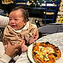 Olivia participe au concours pour gagner de l'argent avec cette photo : adult_hands, baby, background_people, blue_chair, casual, cheese, cheese_pizza, child, crust, dining, food, happy, indoor, marble, pizza, plate, restaurant, seat, smiling, table