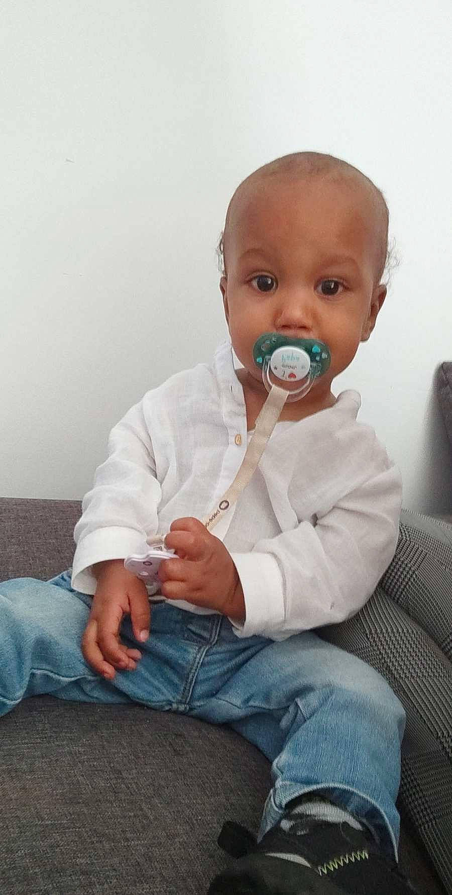 Curtis participe au concours pour gagner de l'argent avec cette photo : audio_equipment, baby, baby_products, baby_toddler_clothing, cheek, child, comfort, couch, denim, drinkware, finger, gesture, happy, lip, nose, person, sitting, skin, sleeve, thumb