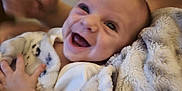 Desmond is registered to the contest to win money with this photo: baby, smiling, blanket, infant, hand, cozy, person, happy, indoor, candid, cute, soft, warm, skin, face, child, toddler, parent, family, comfort