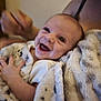 baby, smiling, blanket, infant, hand, cozy, person, happy, indoor, candid, cute, soft, warm, skin, face, child, toddler, parent, family, comfort
