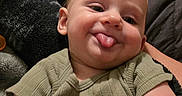 Desmond joined the competition — help win amazing prizes! arm, baby, blanket, cheeky, child, cozy, cute, expression, face, green_clothing, head, indoors, infant, person, playful, sitting, smiling, soft_texture, tongue_out, young