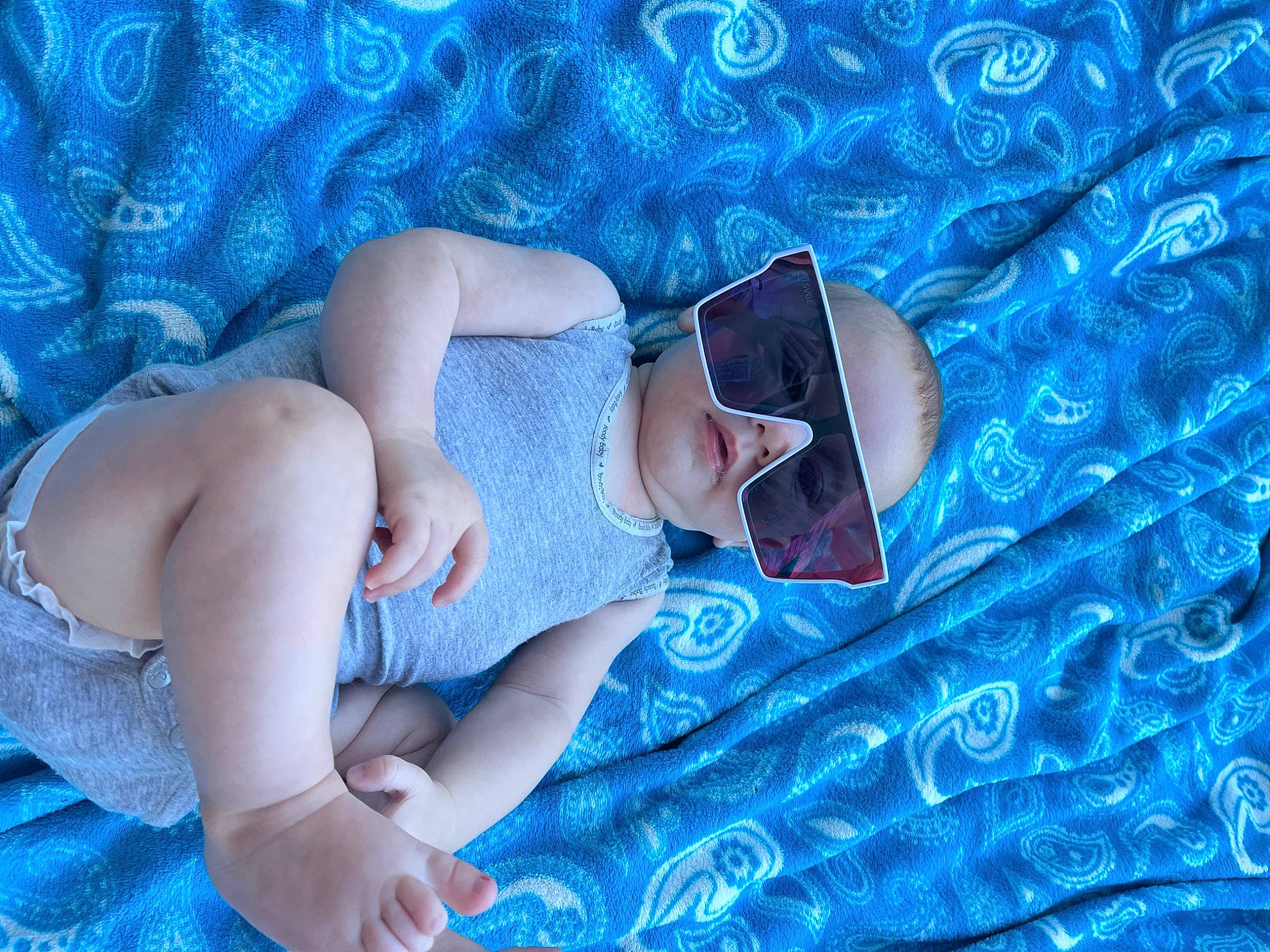 Layton is registered to the contest to win money with this photo: aqua, azure, blue, child, comfort, elbow, electric_blue, eyewear, finger, fun, grass, hat, human_leg, leisure, linens, muscle, pattern, person, sunglasses, textile
