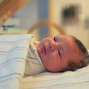 Carson joined the competition — help win amazing prizes! baby, newborn, blanket, striped, face, infant, sleepy, resting, indoors, nursery, soft_light, portrait, closeup, head, person, cozy, child, lying_down, cute, wrapped