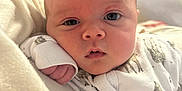 Hudson joined the competition — help win amazing prizes! baby, infant, close_up, face, onesie, animal_prints, blanket, soft, indoors, curious, resting, hand, expression, cute, child, portrait, newborn, cozy, sleepwear, young