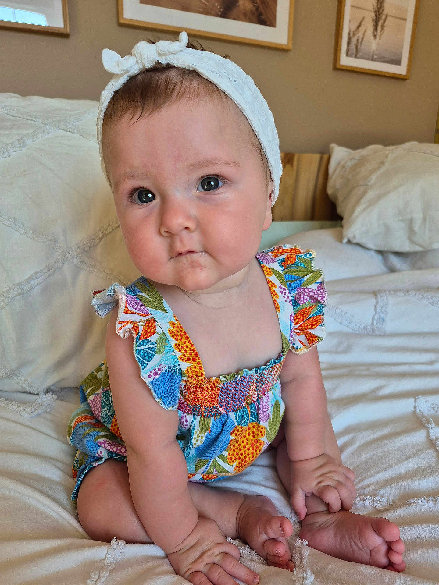 Léa participe au concours pour gagner de l'argent avec cette photo : baby, child, infant, headband, colorful_dress, sitting, bed, pillow, indoor, portrait, cute, hands, feet, skin, face, eyes, photography, room, decor, framed_photos