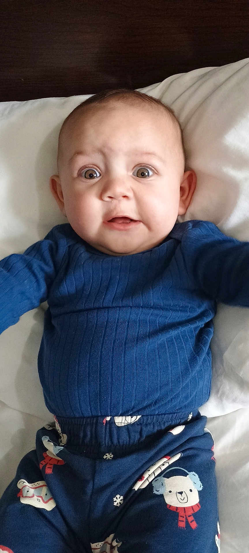 Jiraiya is registered to the contest to win money with this photo: baby, child, infant, blue_clothing, pajamas, bear_pattern, snowflake_pattern, lying_down, white_pillow, cute, wide_eyes, surprised_expression, indoors, portrait, young_child, sleepwear, head, face, person, cozy