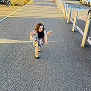 Cynthia a rejoint le concours — aidez-le/la à gagner de superbes lots ! bollards, building, car, child, coat, handbag, parking_lot, pavement, pedestrian, plaid_skirt, scooter, shadow, shoes, sidewalk, sign, sunglasses, sunlight, toddler, urban, walking