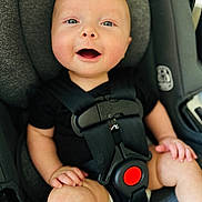 Wyatt joined the competition — help win amazing prizes! baby, child, car_seat, safety_harness, smiling, happy, infant, seatbelt, black_clothing, red_button, cute, young_child, secure, car_interior, closeup, face, skin, hands, legs, seat
