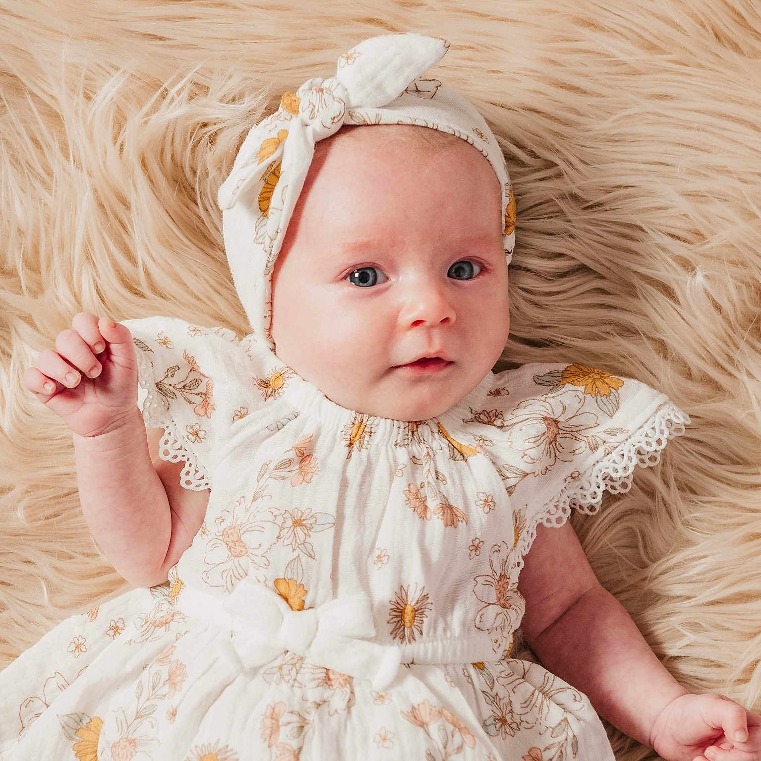 Hazelle is registered to the contest to win money with this photo: baby, blonde, bodypart, bonnet, clothing, dress, face, finger, hair, hand, happy, hat, head, newborn, person, photography, portrait, sitting, smile, toy