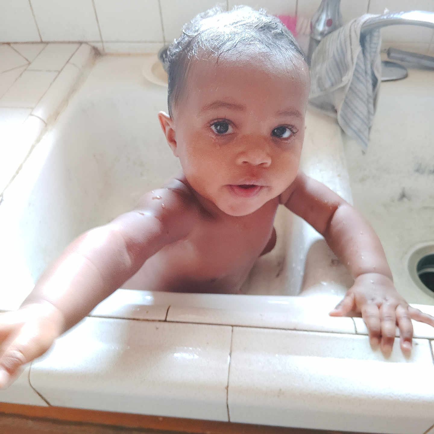 Jahnetta is registered to the contest to win money with this photo: baby, bathing, bathtub, bodypart, face, finger, hand, head, newborn, person, photography, portrait, sink, tile, tub