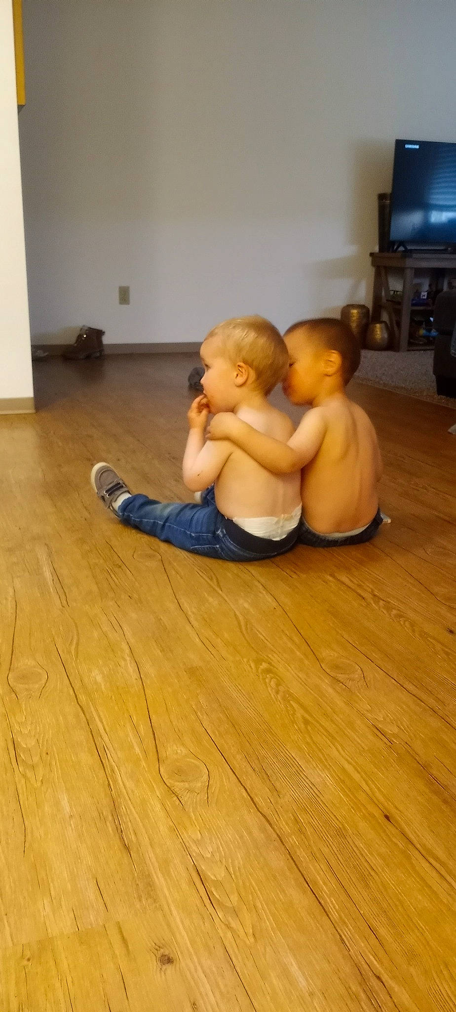 Lucian is registered to the contest to win money with this photo: abdomen, arm, barefoot, chest, comfort, finger, floor, flooring, foot, hardwood, human_body, human_leg, knee, laminate_flooring, person, television, toddler, trunk, varnish, wood