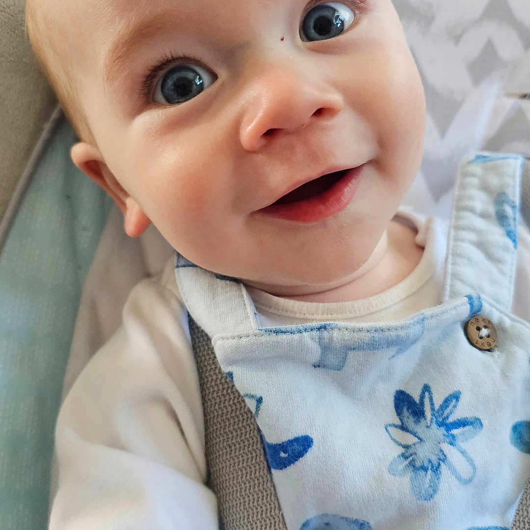 Gerald is registered to the contest to win money with this photo: accessories, baby, clothing, coat, cushion, dress, face, furniture, happy, head, homedecor, jeans, laughing, newborn, pants, person, photography, portrait, smile, strap