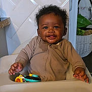 Kiki joined the competition — help win amazing prizes! baby, high_chair, toy, smiling, indoor, child, cozy_clothing, happy, cute, infant, person, face, hand, kitchen, home, furniture, seat, playtime, expression, young_child