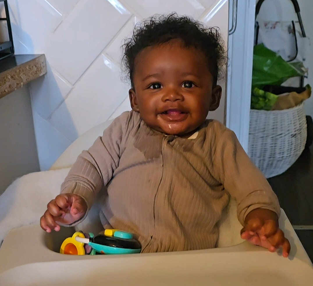 Kiki joined the competition — help win amazing prizes! baby, high_chair, toy, smiling, indoor, child, cozy_clothing, happy, cute, infant, person, face, hand, kitchen, home, furniture, seat, playtime, expression, young_child