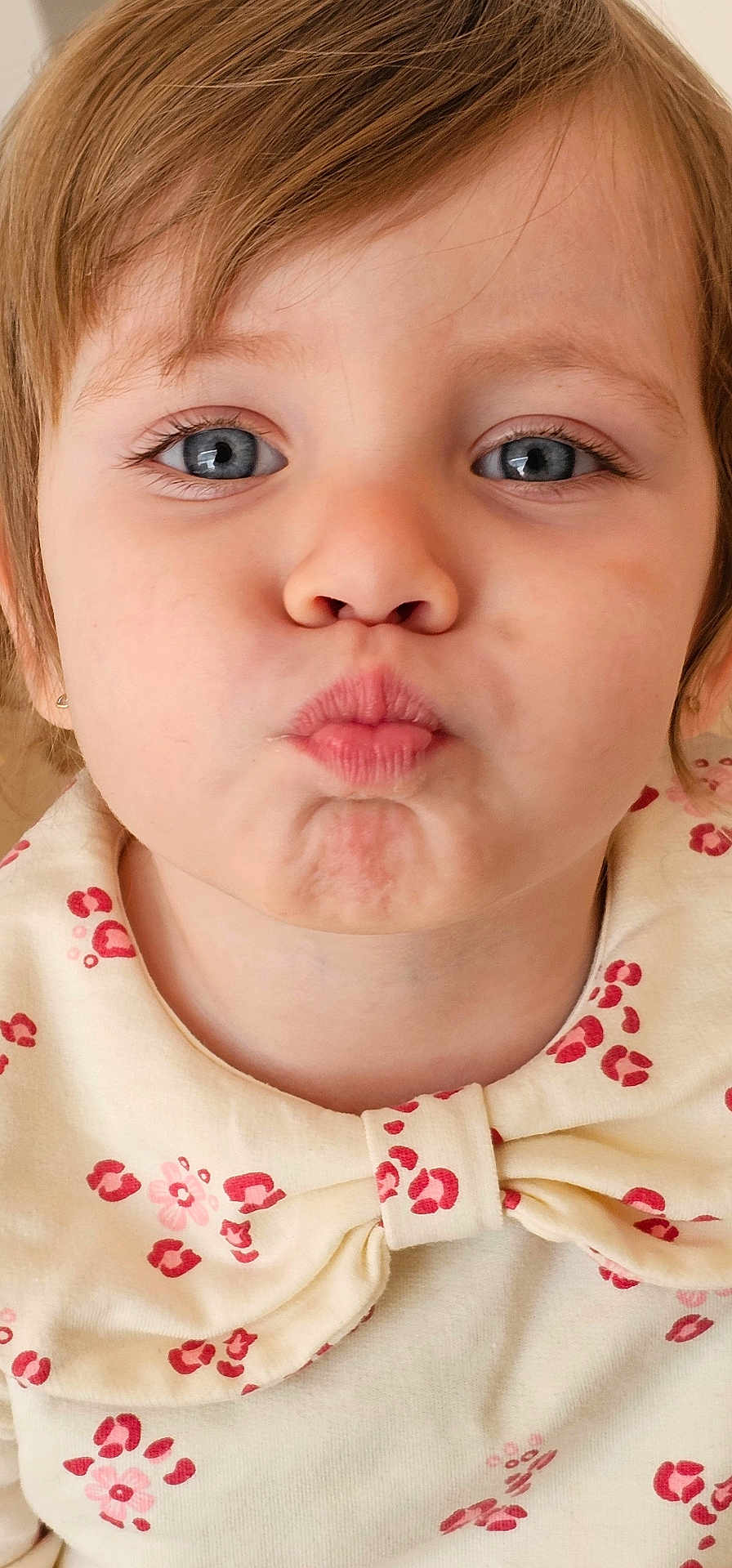 Miruna participe au concours pour gagner de l'argent avec cette photo : child, toddler, portrait, close_up, blue_eyes, pursed_lips, playful_expression, short_hair, earring, natural_skin, nose, mouth, eyelashes, bow_collar, patterned_clothing, indoor, soft_lighting, frontal_face, young_child, adorable