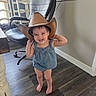 Amberley is registered to the contest to win money with this photo: barefoot, blue_outfit, child, childhood, cowboy, cowboy_hat, denim, dining_chairs, flexing, happy, home, indoor, office_chair, photography, playful, portrait, smiling, standing, toddler, wood_floor