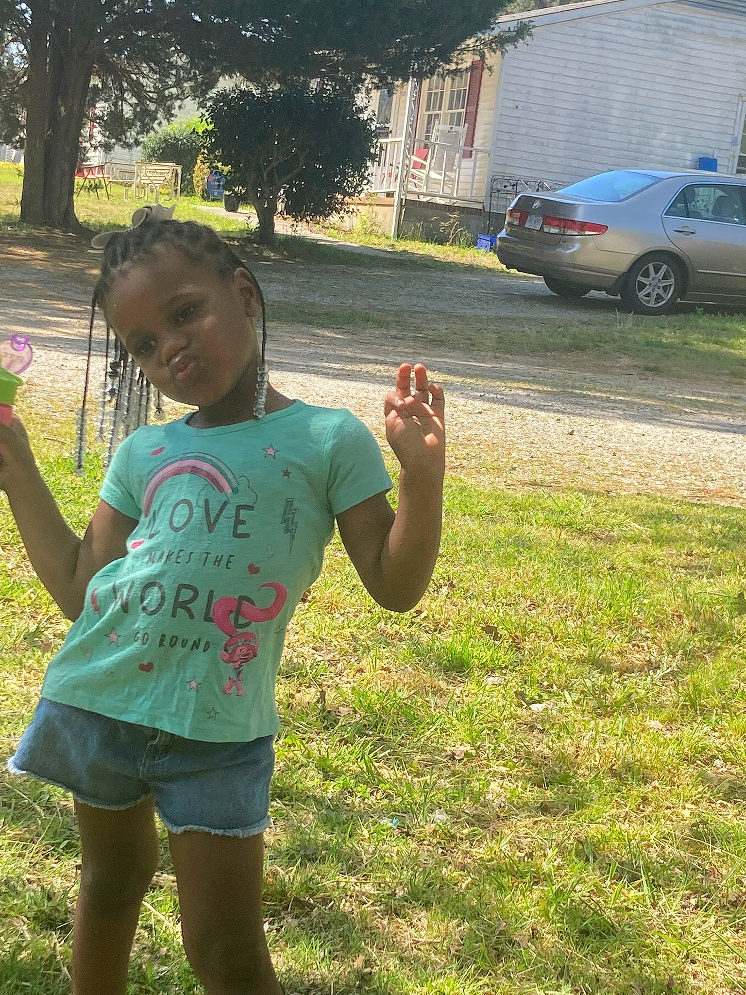 Skylar is registered to the contest to win money with this photo: car, cool, finger, fun, grass, happy, leaf, leisure, morning, people_in_nature, person, plant, public_space, recreation, smile, summer, sunlight, t_shirt, tire, tree