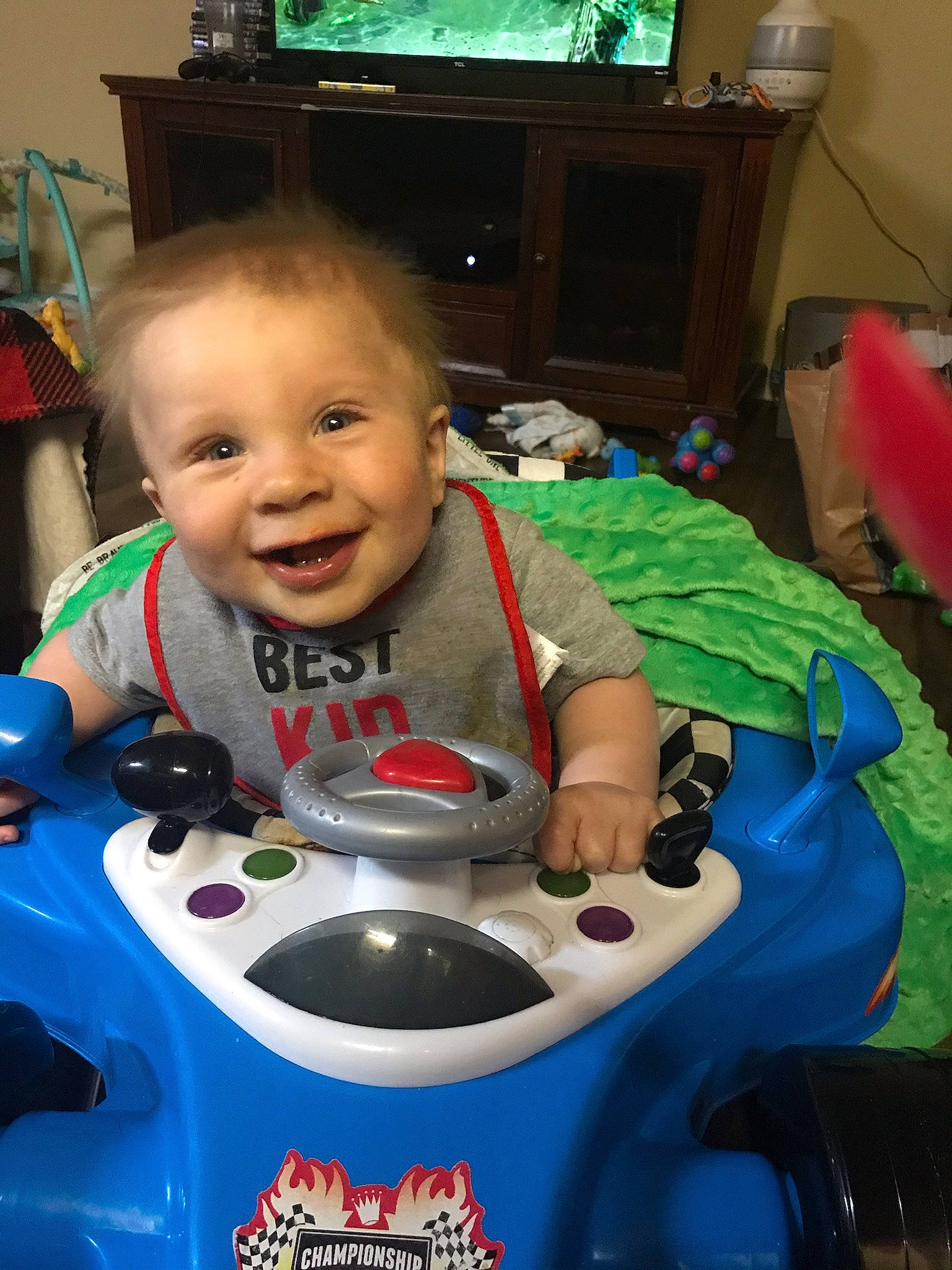 Shiloh joined the competition — help win amazing prizes! automotive_design, baby, baby_toys, blue, child, fictional_character, fun, green, human_body, joy, person, play, recreation, riding_toy, room, smile, technology, television, television_set, toddler