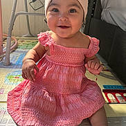 Aylani is registered to the contest to win money with this photo: baby, child, infant, smiling, pink_dress, headband, play_mat, indoors, cute, happy, sitting, person, young_child, bracelet, floor, natural_light, portrait, chubby_arms, clothing, home